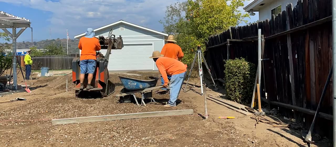 Crew compacting the base and screeding it level