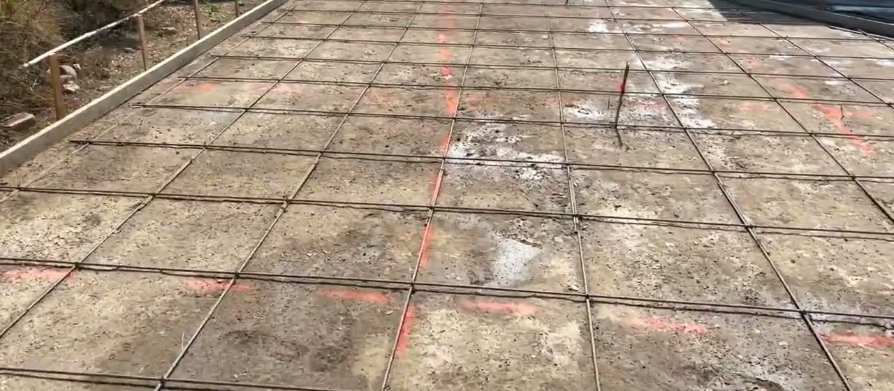 Steel rebar grid laid out across the driveway area