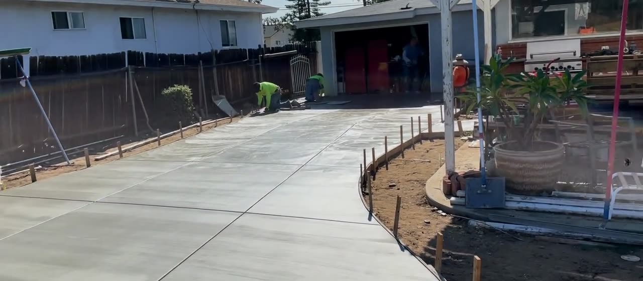 Finished broom-finish concrete driveway leading back to a detached garage in Glendora