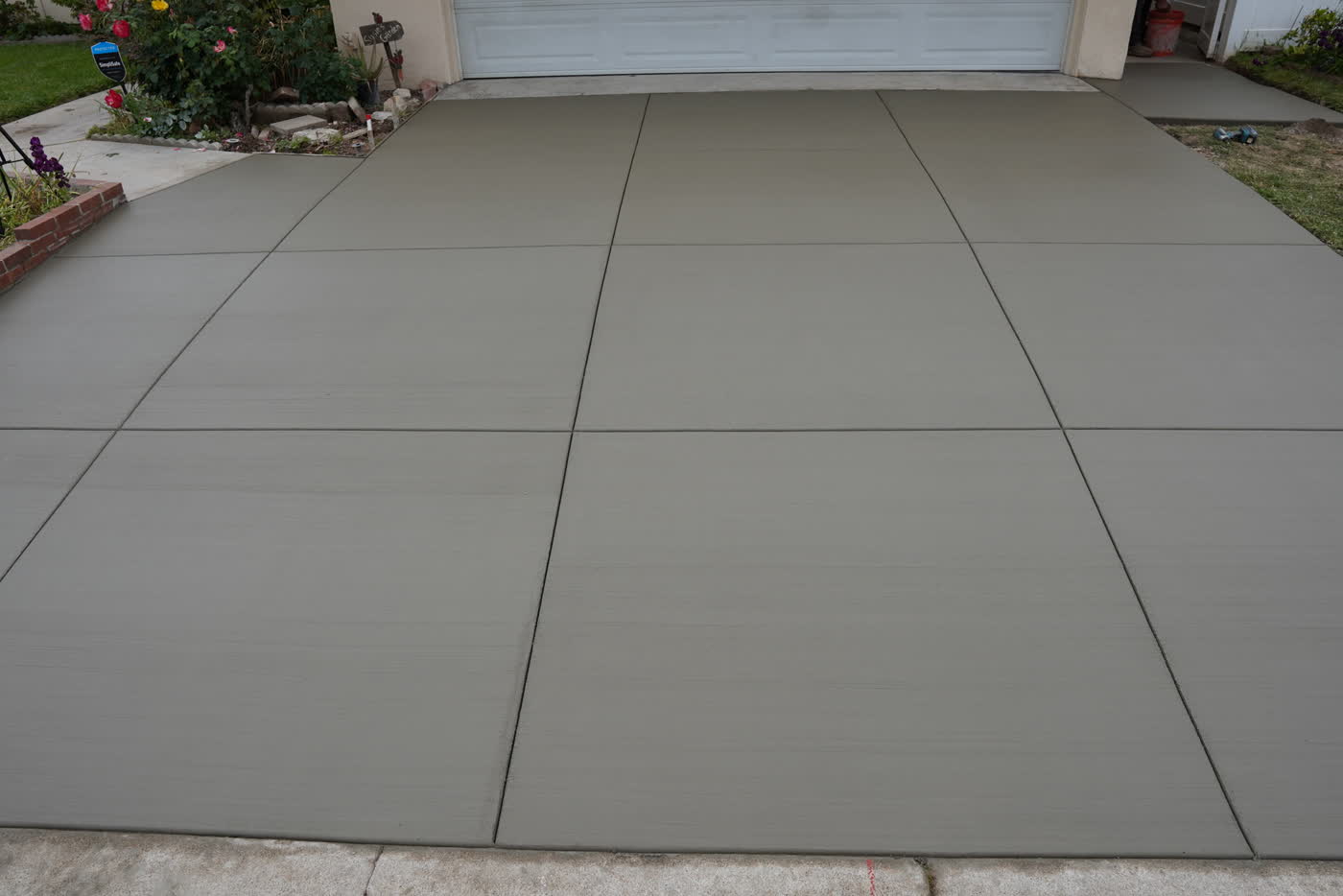 New broom-finish concrete driveway with a square joint pattern in La Habra
