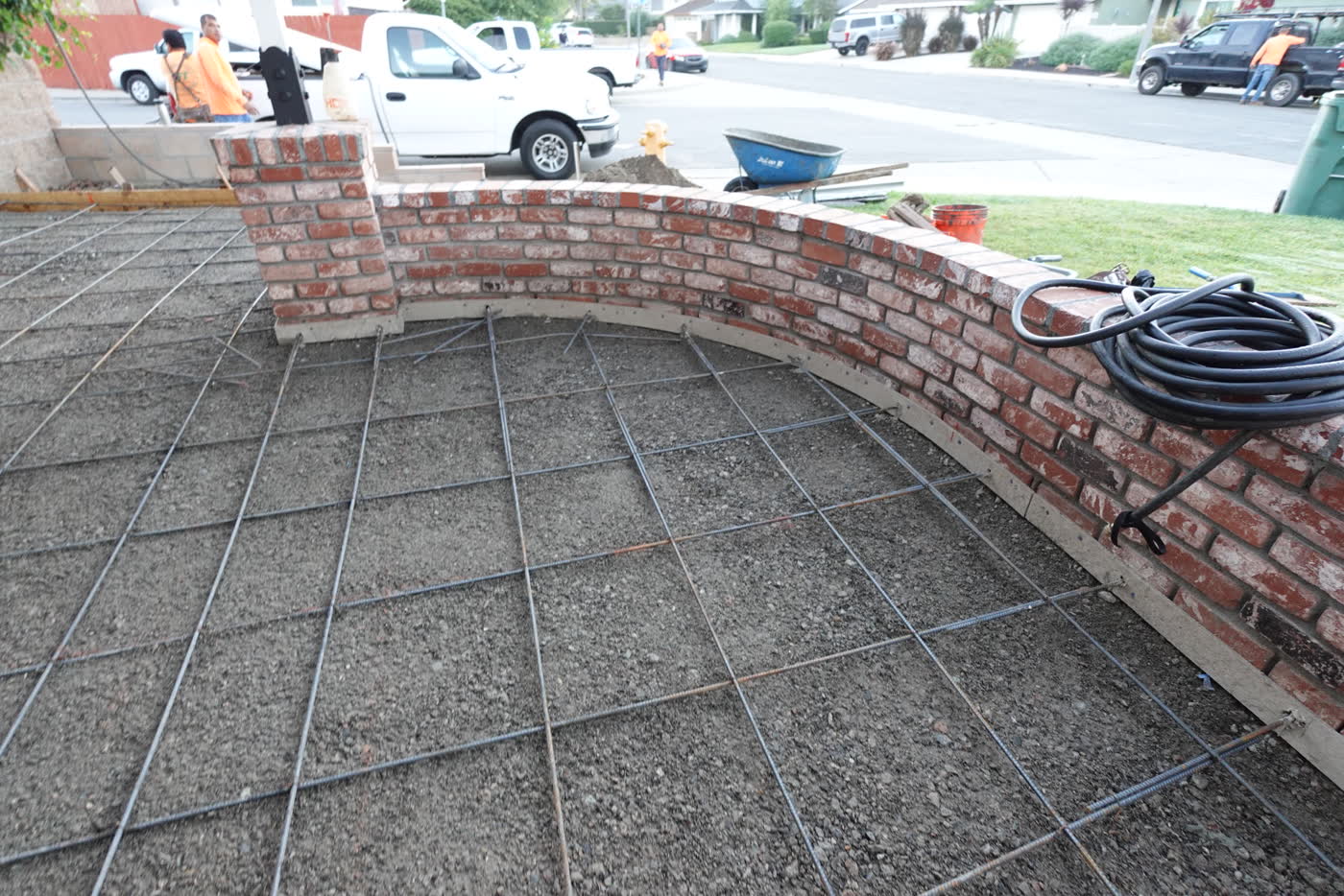 Rebar laid out up to the curved brick planter wall