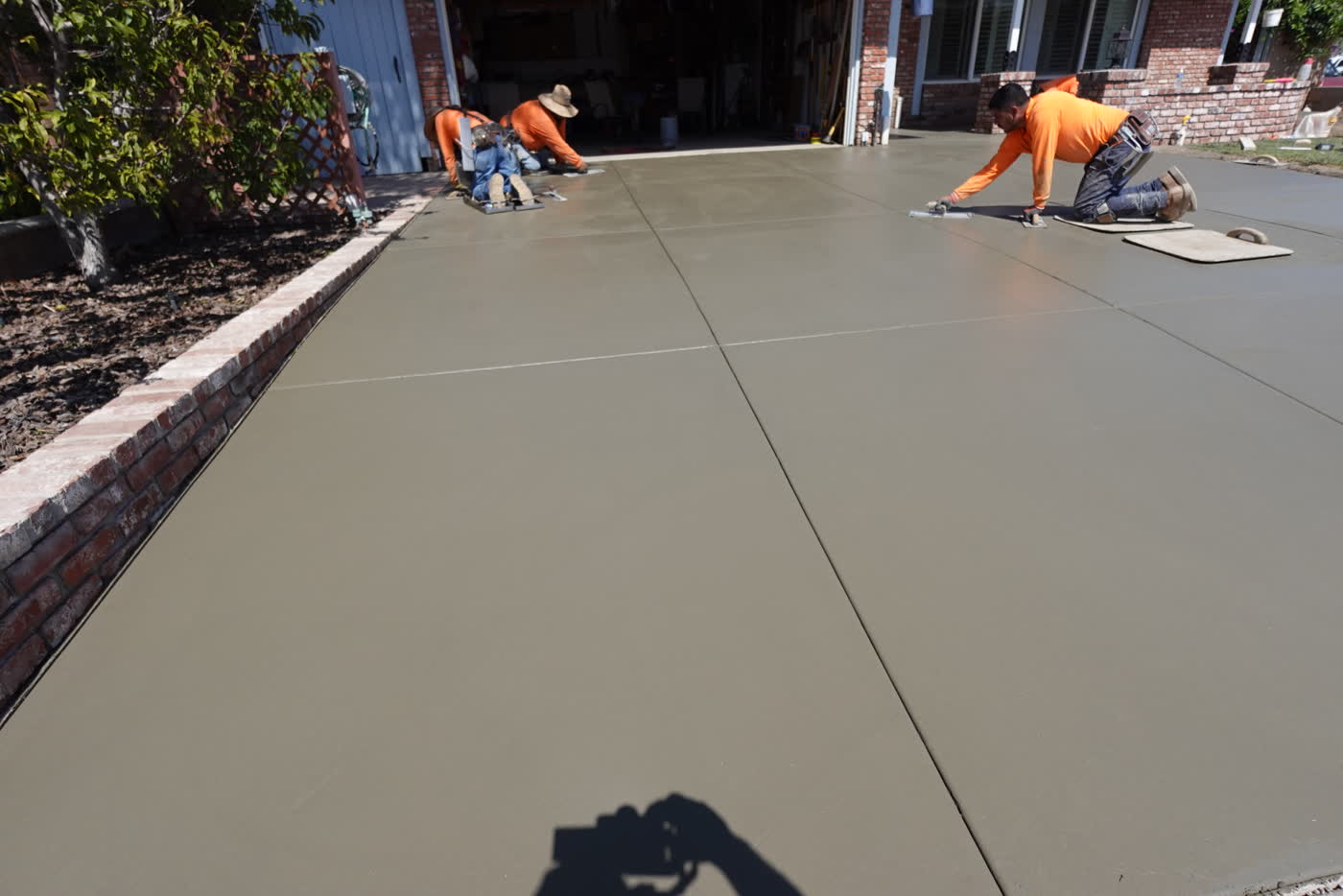 Crew hand-finishing the fresh concrete