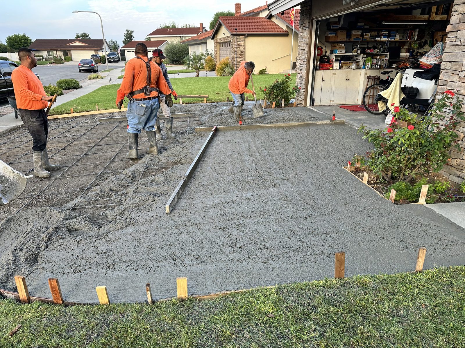 Crew pouring and screeding concrete over rebar