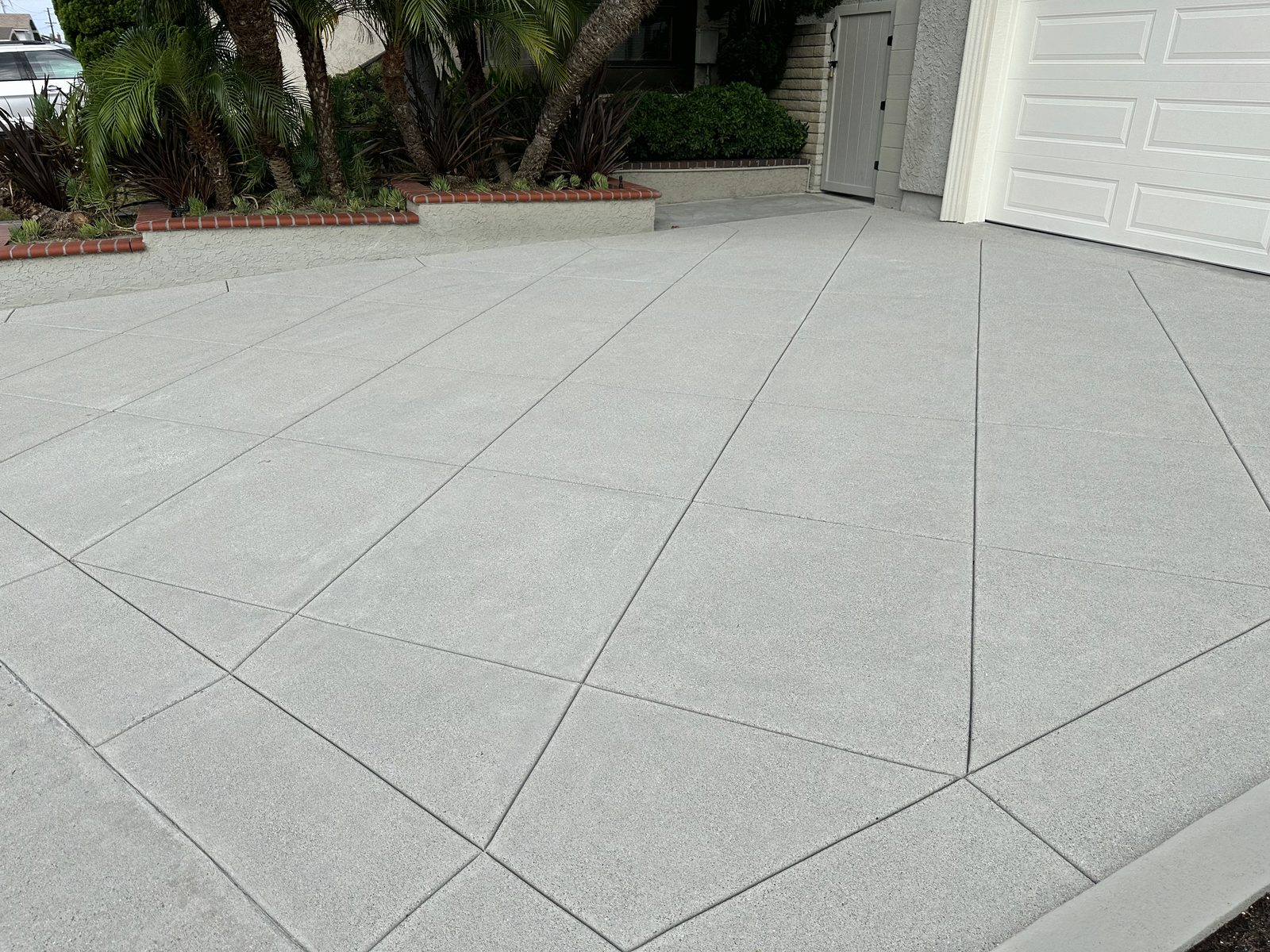 Broom-finish concrete driveway with a diagonal joint pattern