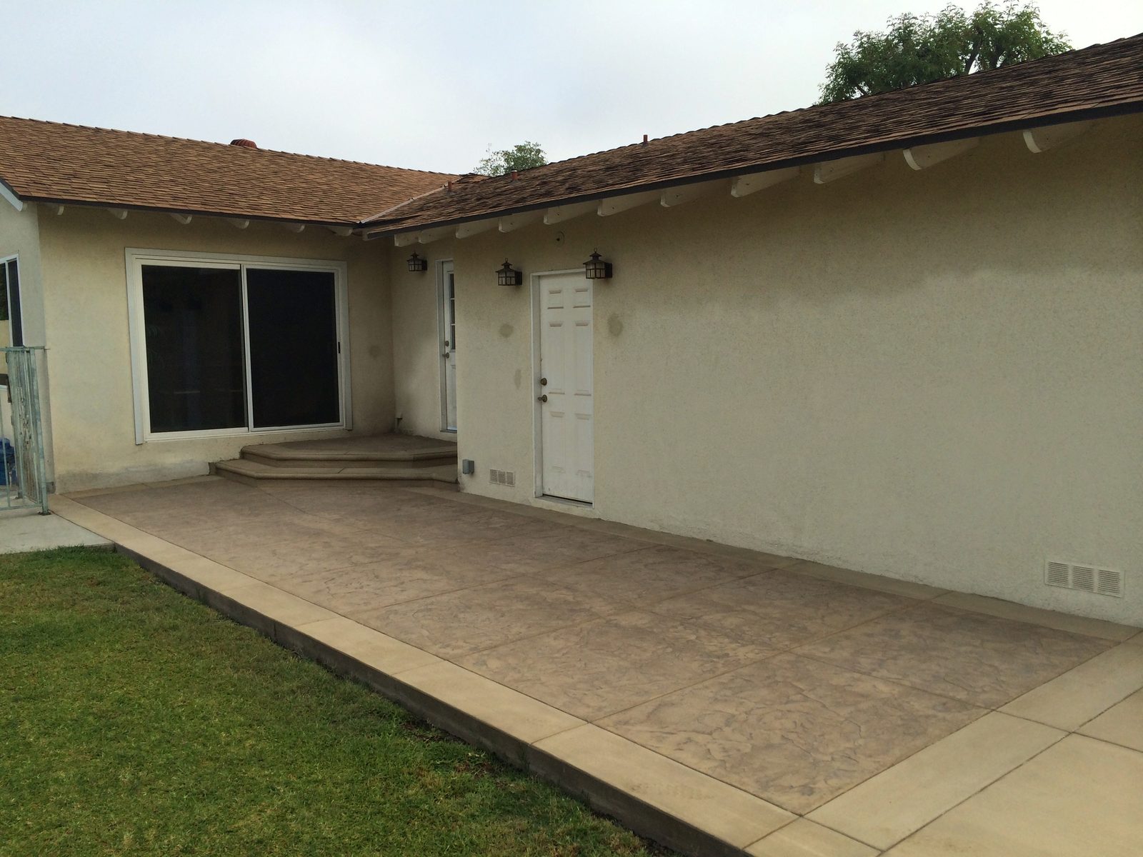 Colored stamped concrete patio with a broom-finish border